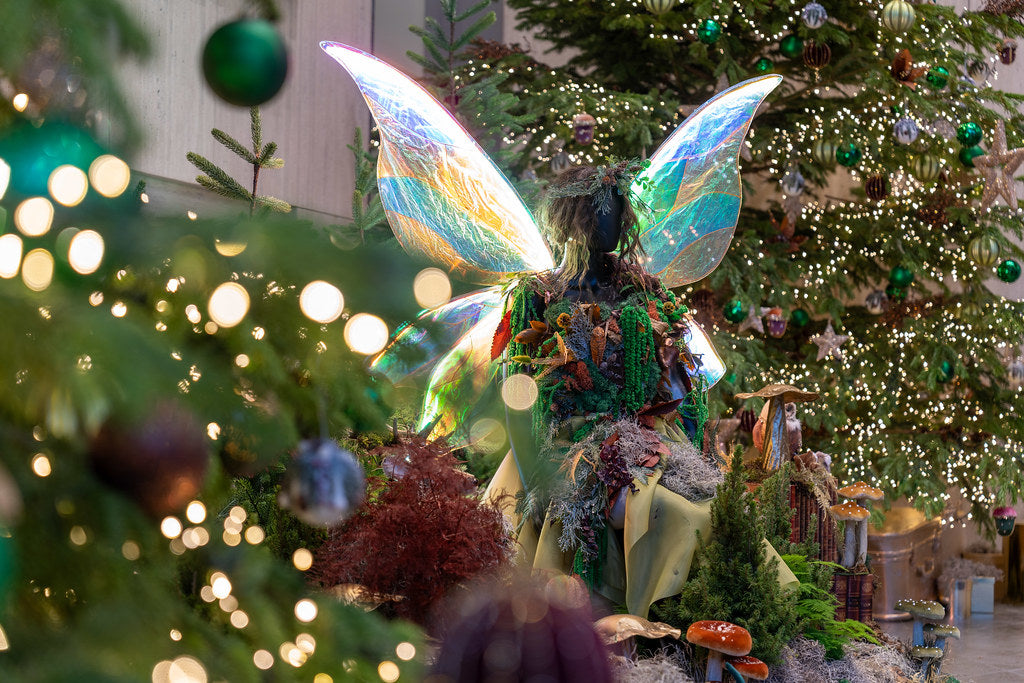 Decorative fairy figure on a Christmas tree with lights and ornaments. London Christmas installation 